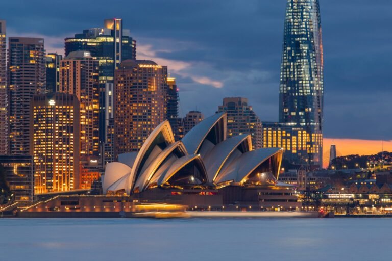 Sydney Opera House with city skyline at dusk