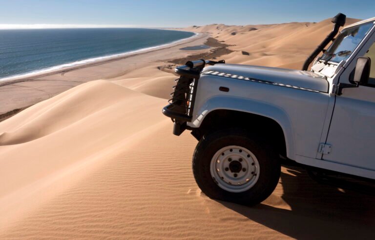 Off-road vehicle on sand dunes by the coast