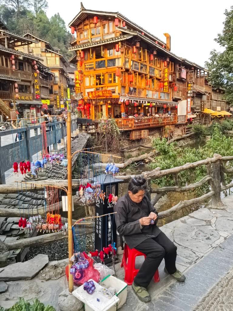 Handicrafts by stream Zhaoxing Dong Village Yunnan Guizhou China tour GoGo Tours