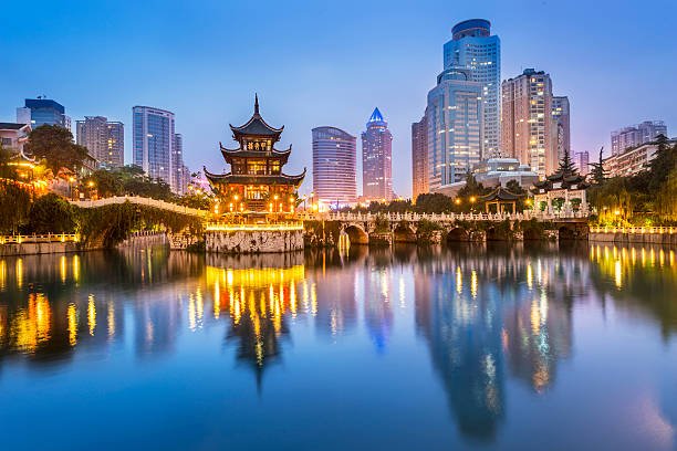 Jiaxiu Tower in Guiyang with modern skyline at dusk