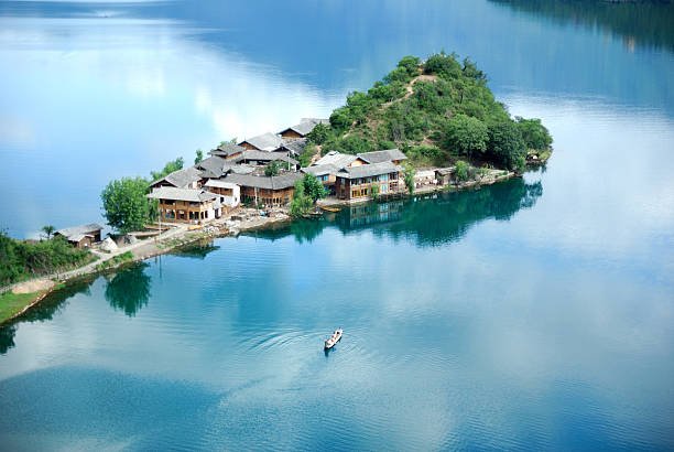 Scenic view of Lugu Lake with an island and boat.