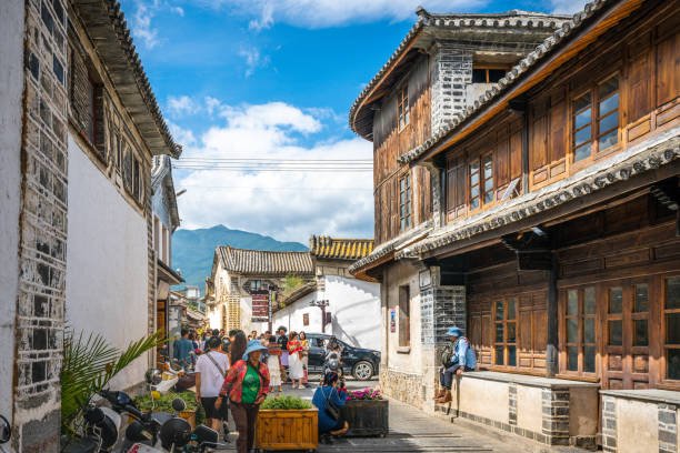 Street market in Xizhou Ancient Town with traditional wooden buildings.