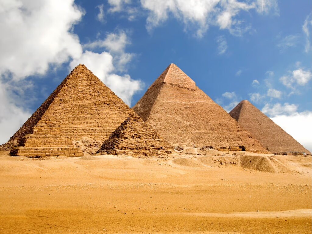 The Pyramids of Giza under a blue sky.