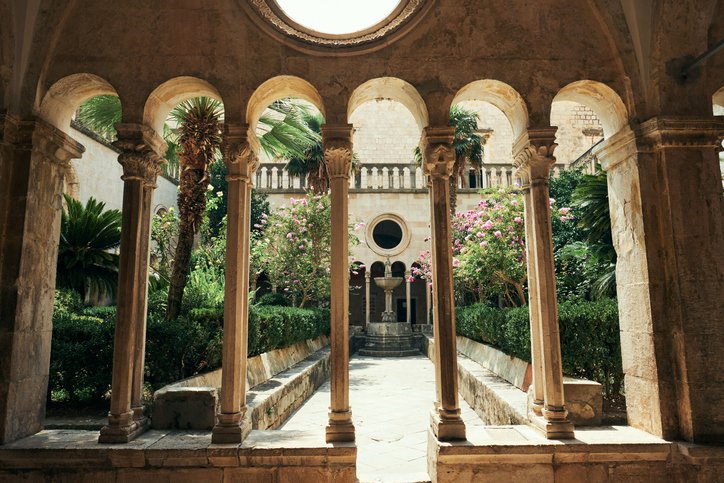 Historical monastery courtyard with arches and garden