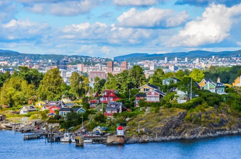 Colorful houses on the Oslo waterfront with the city skyline.