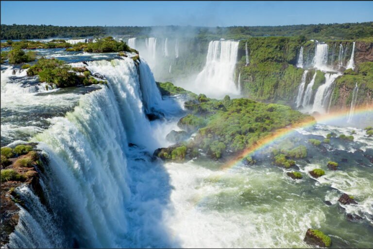 Iguazu Falls with a rainbow and lush green surroundings